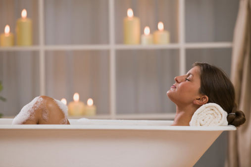 Woman in bath with candles